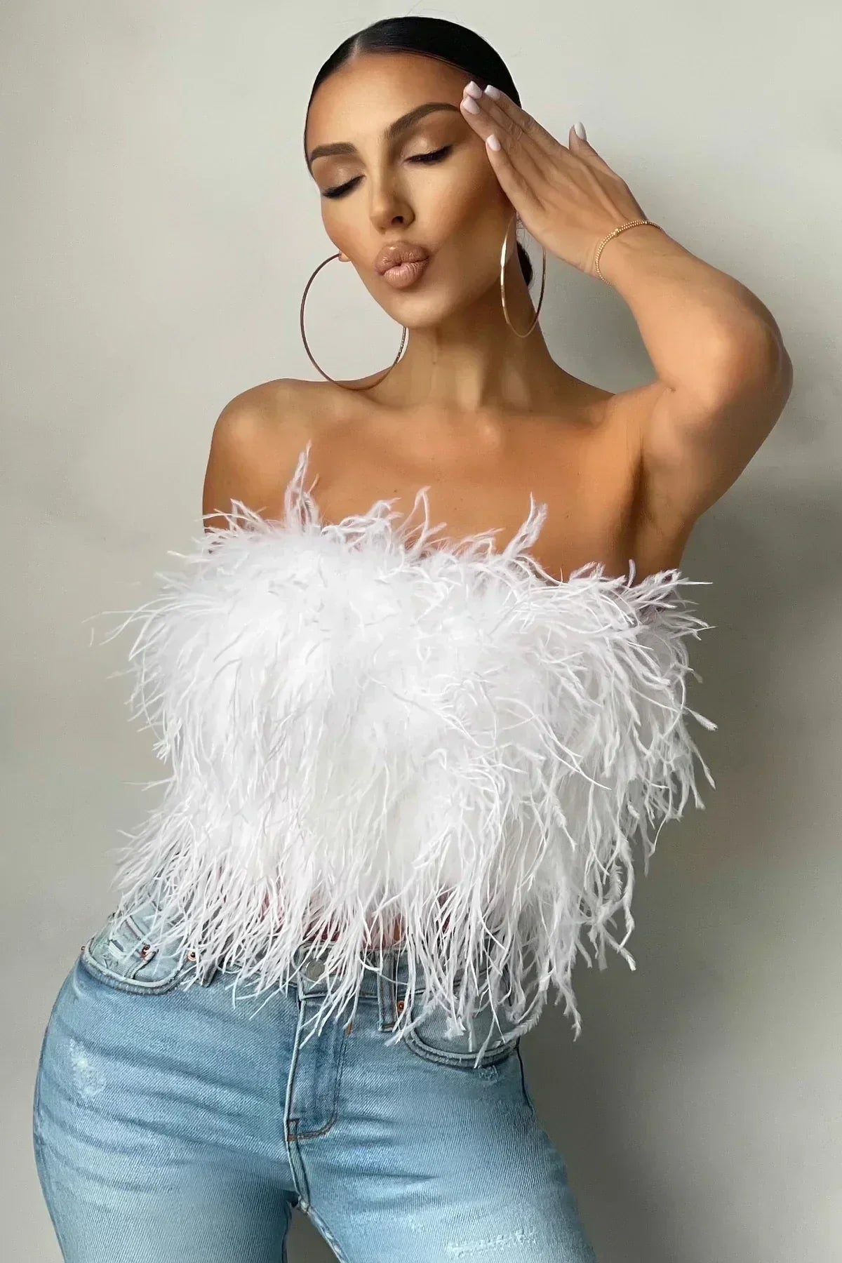 Trendy feather crop top for women, a chic sleeveless statement piece.